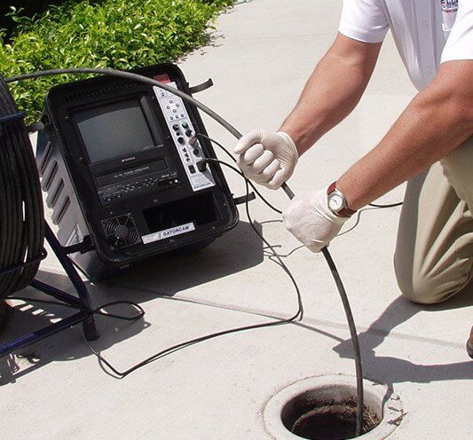 american leak detection of southwest florida technician using a sewer camera to inspect drains on a residential property